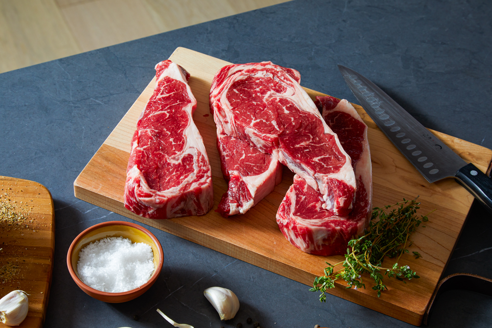 Ribeye steaks on a butcher block