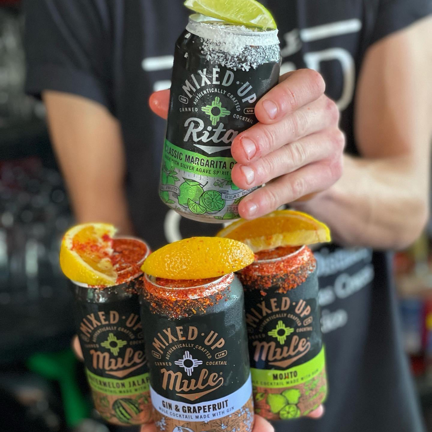 Person holding an assortment of Mixed-Up cans.