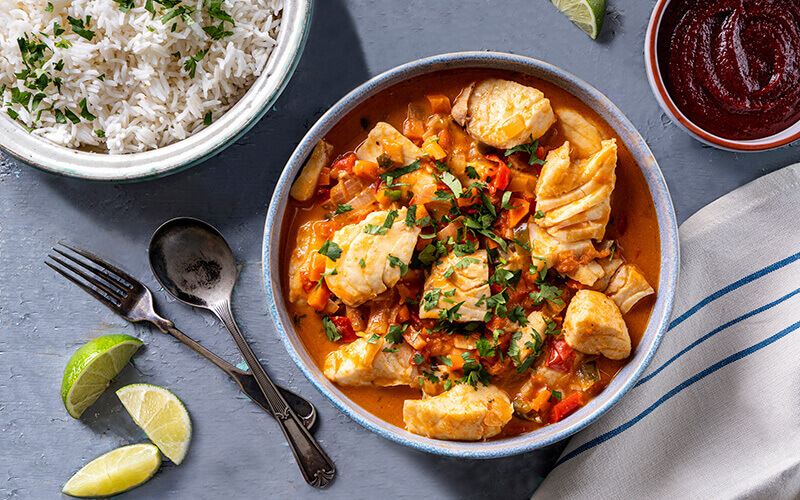 bowl of rice and bowl of halibut in red sauce