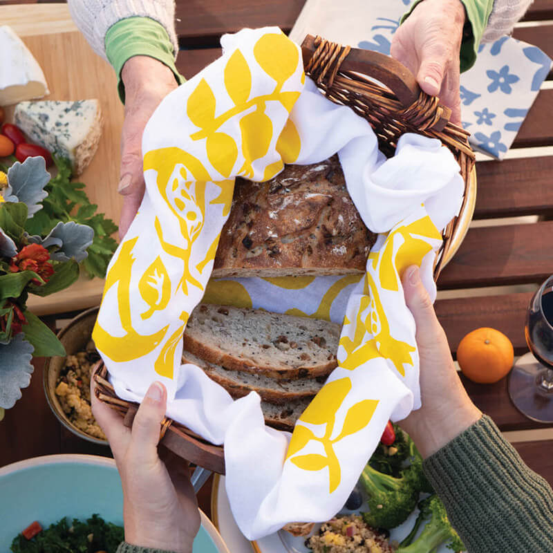 Hands holding basket of bread