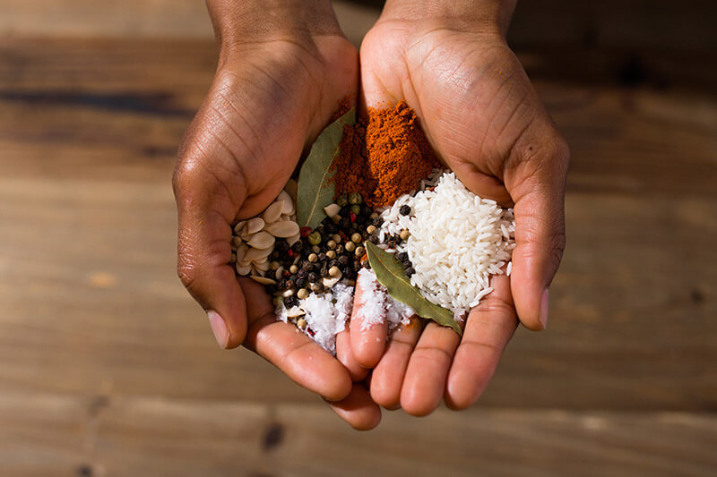 Hands cupping rice and spices